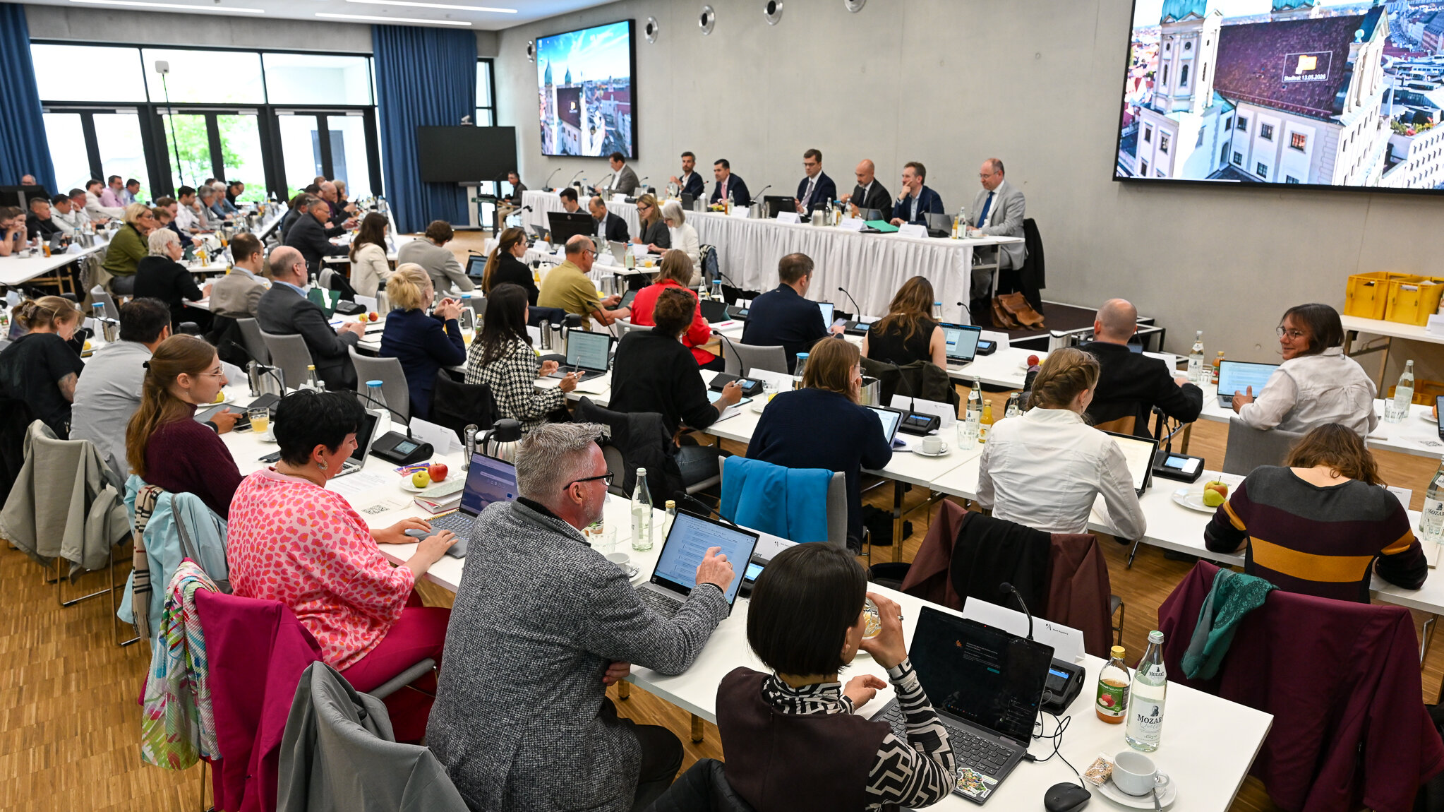 Viele Menschen sitzen an langen tischen und diskutieren