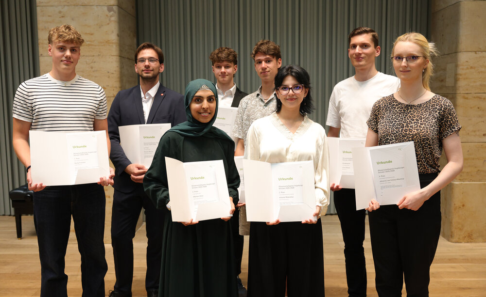 Das Foto zeigt die sieben Preisträgerinnen. In der vorderen Reihe stehen drei junge Frauen, in der hinteren vier junge Männer. Sie halten alle eine Urkunde in den Händen und lächeln in die Kamera