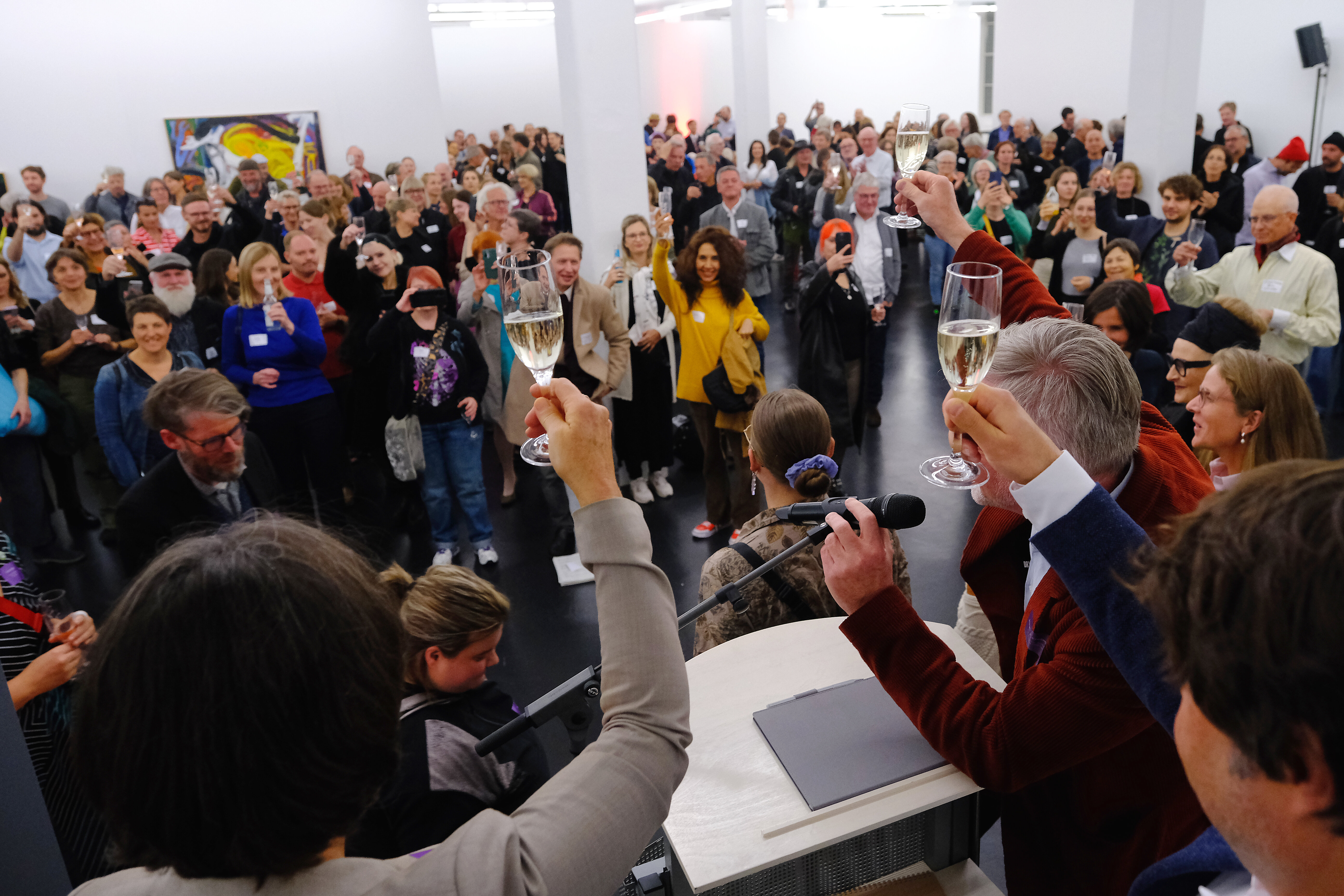 Viele Leute in einem Saal. Sie haben Sektgläser in der Hand