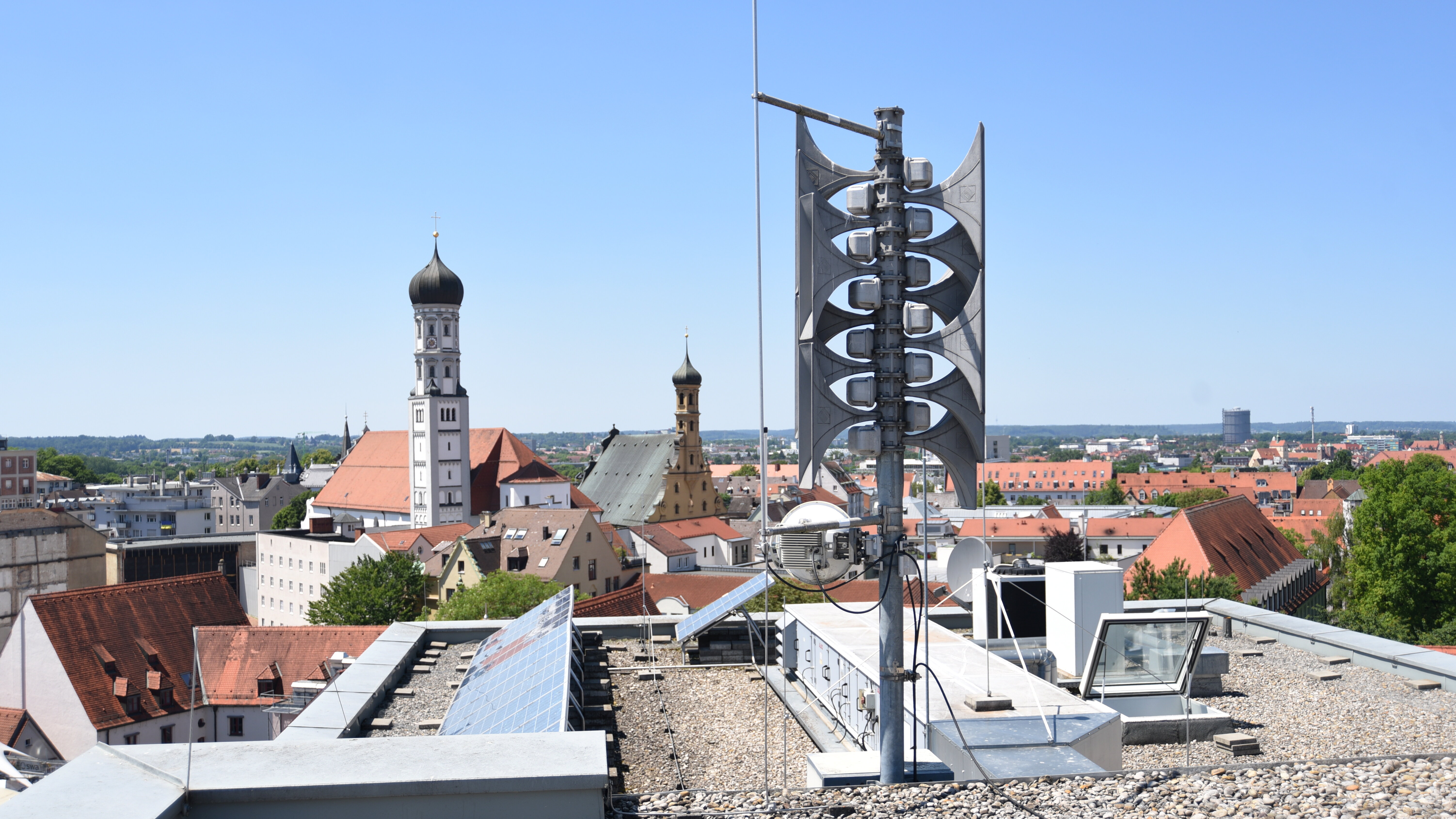 Sirene auf einem Dach mit Ausblick auf die Innenstadt, u.a. dem Turm von St. Ulrich