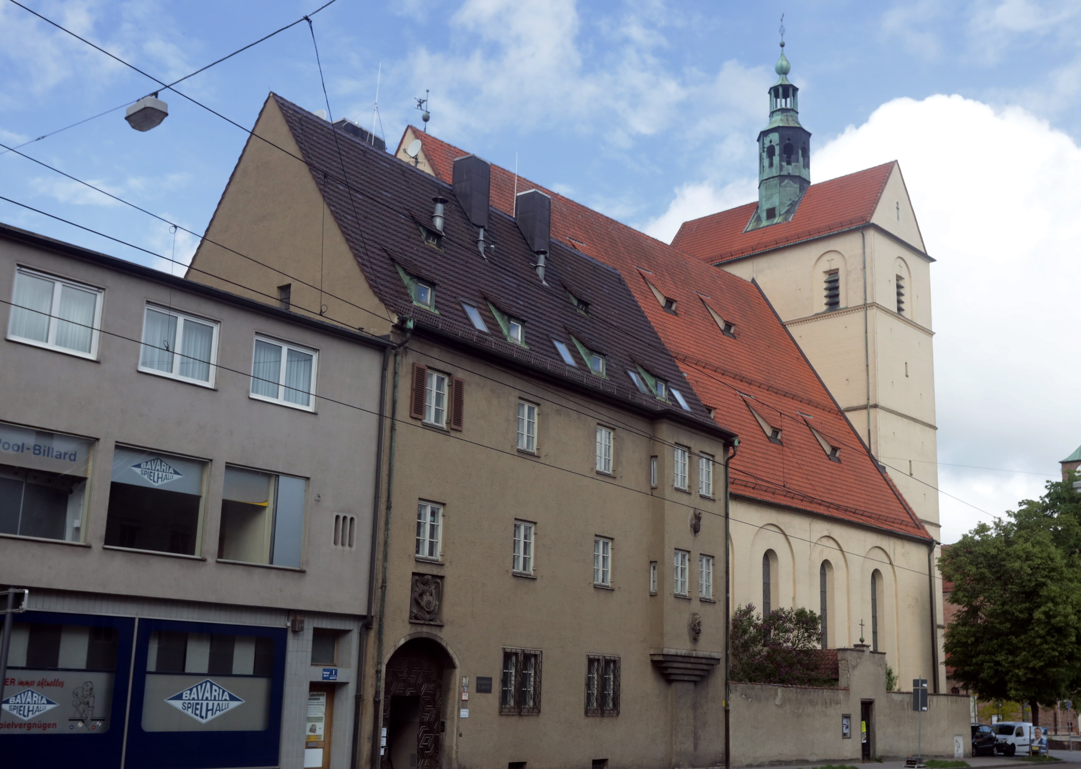 Eine Kirche mit Pfarrheim an einer großen Straße