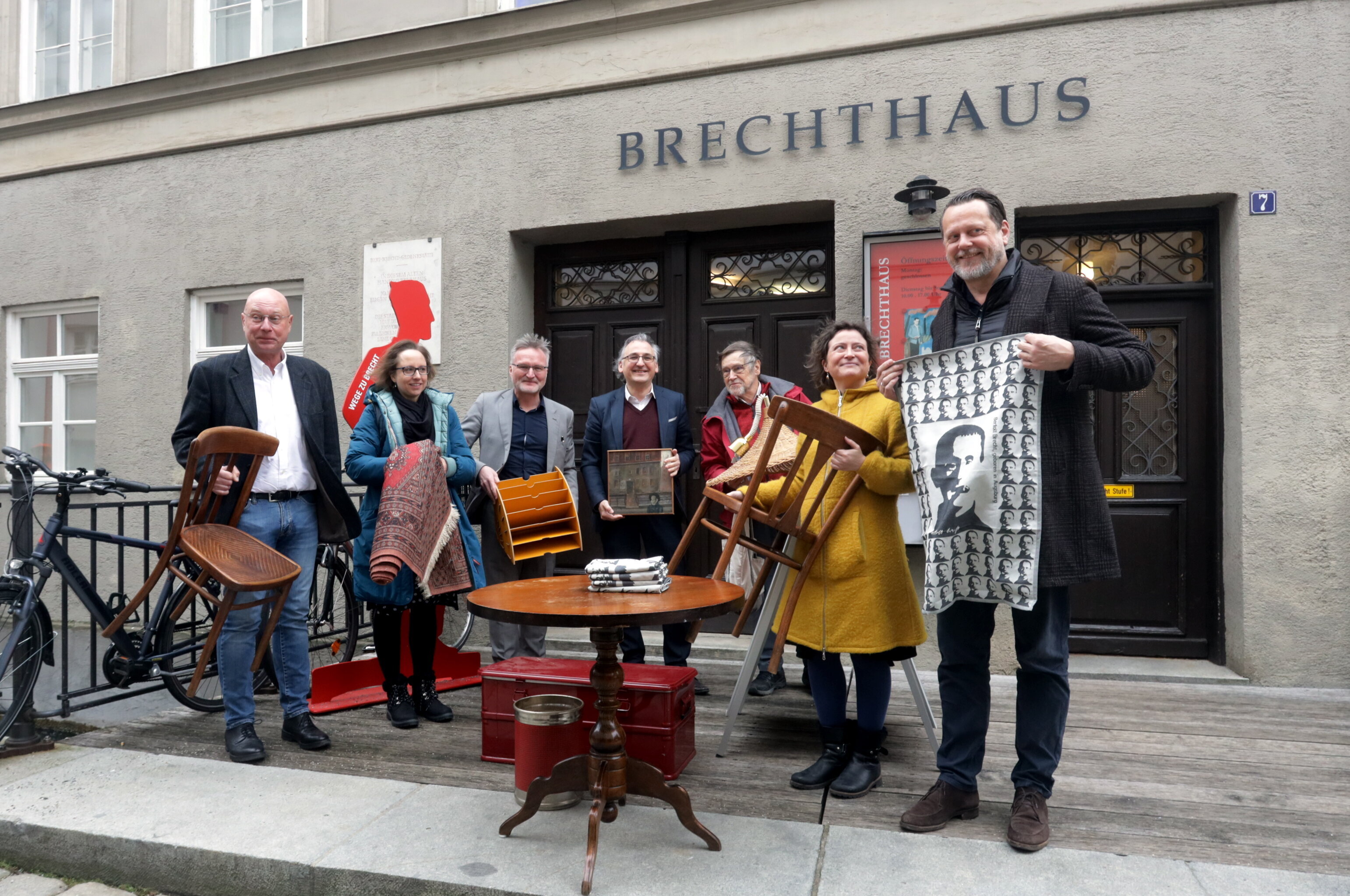 Eine Gruppe von Kulturschaffenden steht vor dem Geburtshaus von Bert Brecht in der Augsburger Altstadt.
