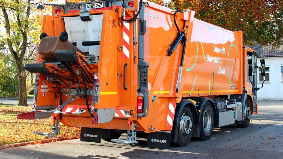 orangefarbenes Tonnenfahrzeug mit Aufkleber "aws"