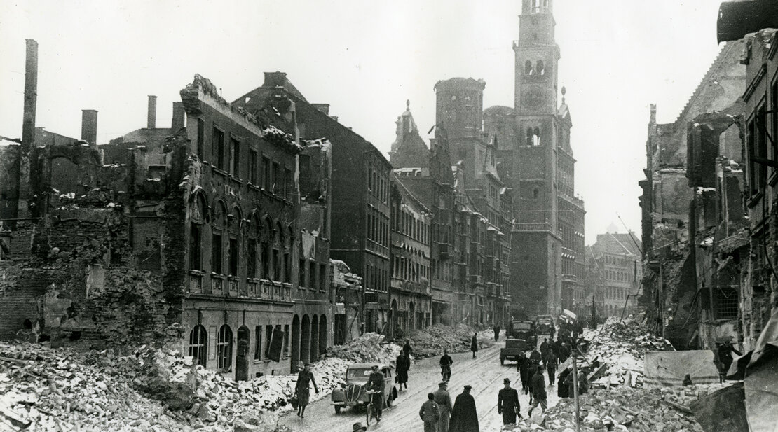 Eine schwarz-weiß Aufnahme der zerstörten Karolinenstraße der Augsburger Bombennacht.