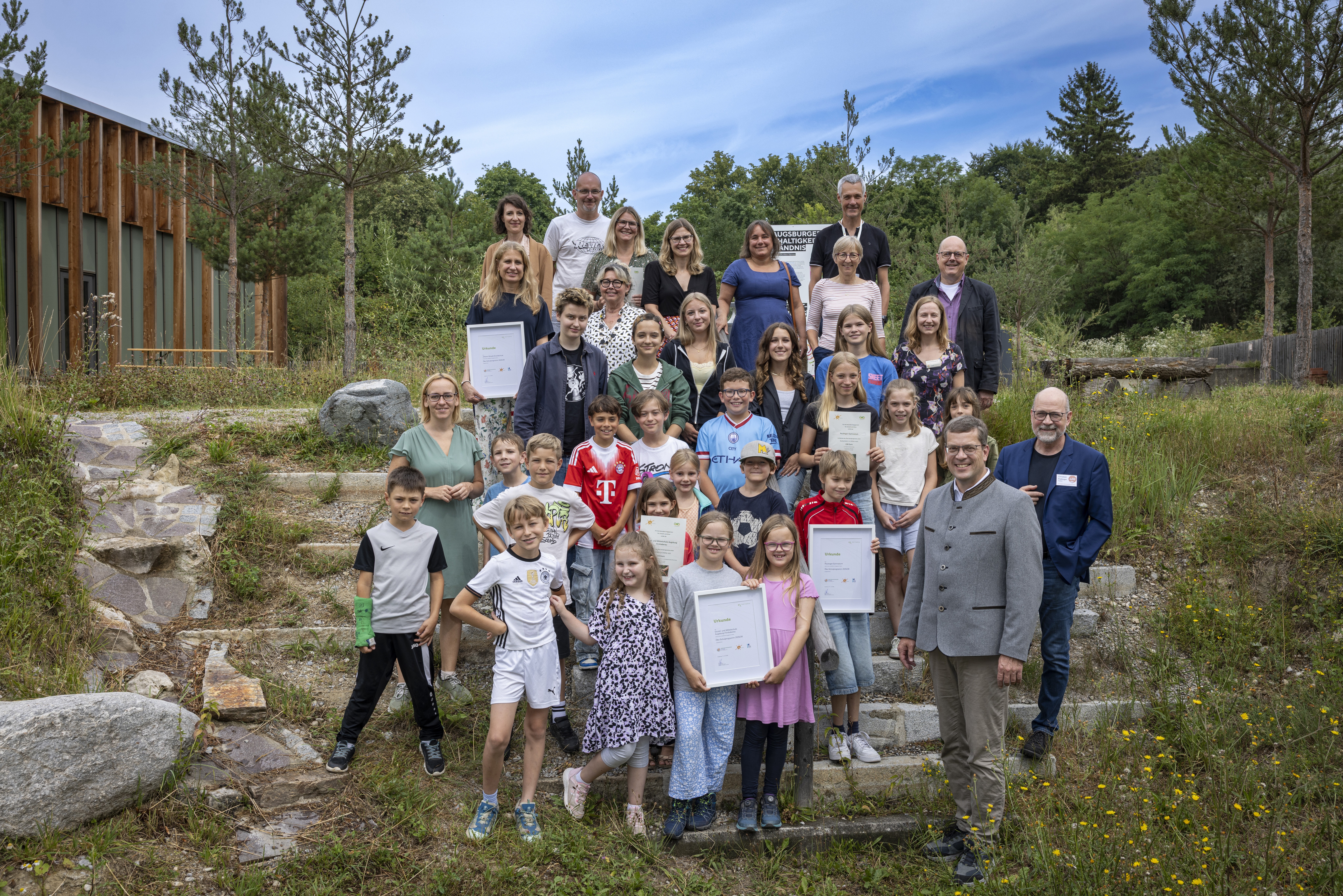 Kinder und Erwachsene posieren für ein Gruppenfoto auf einer Treppe.
