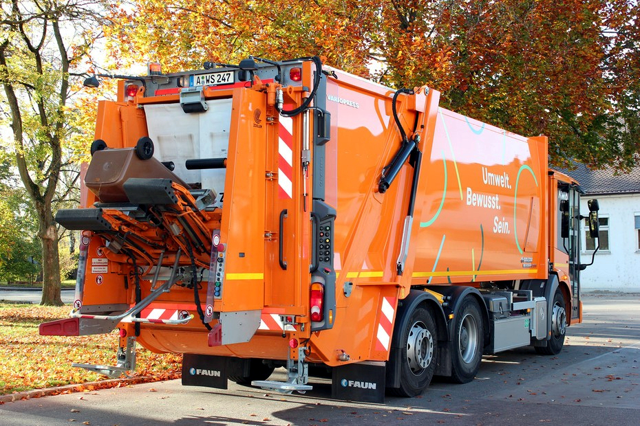 Ein Müllfahrzeug leert eine Braune Tonne