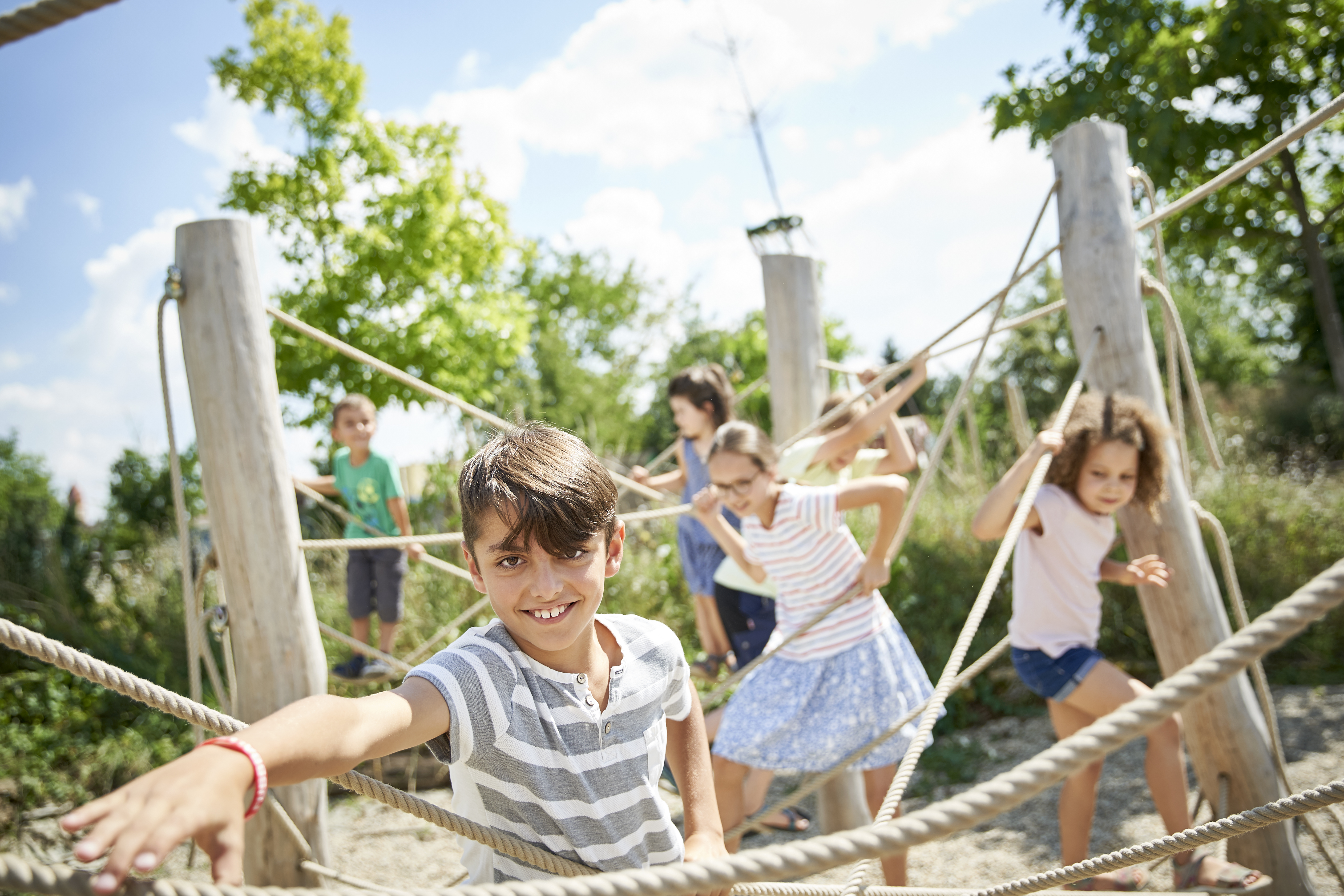 Kinder klettern an Seilen auf einem Spielplatz