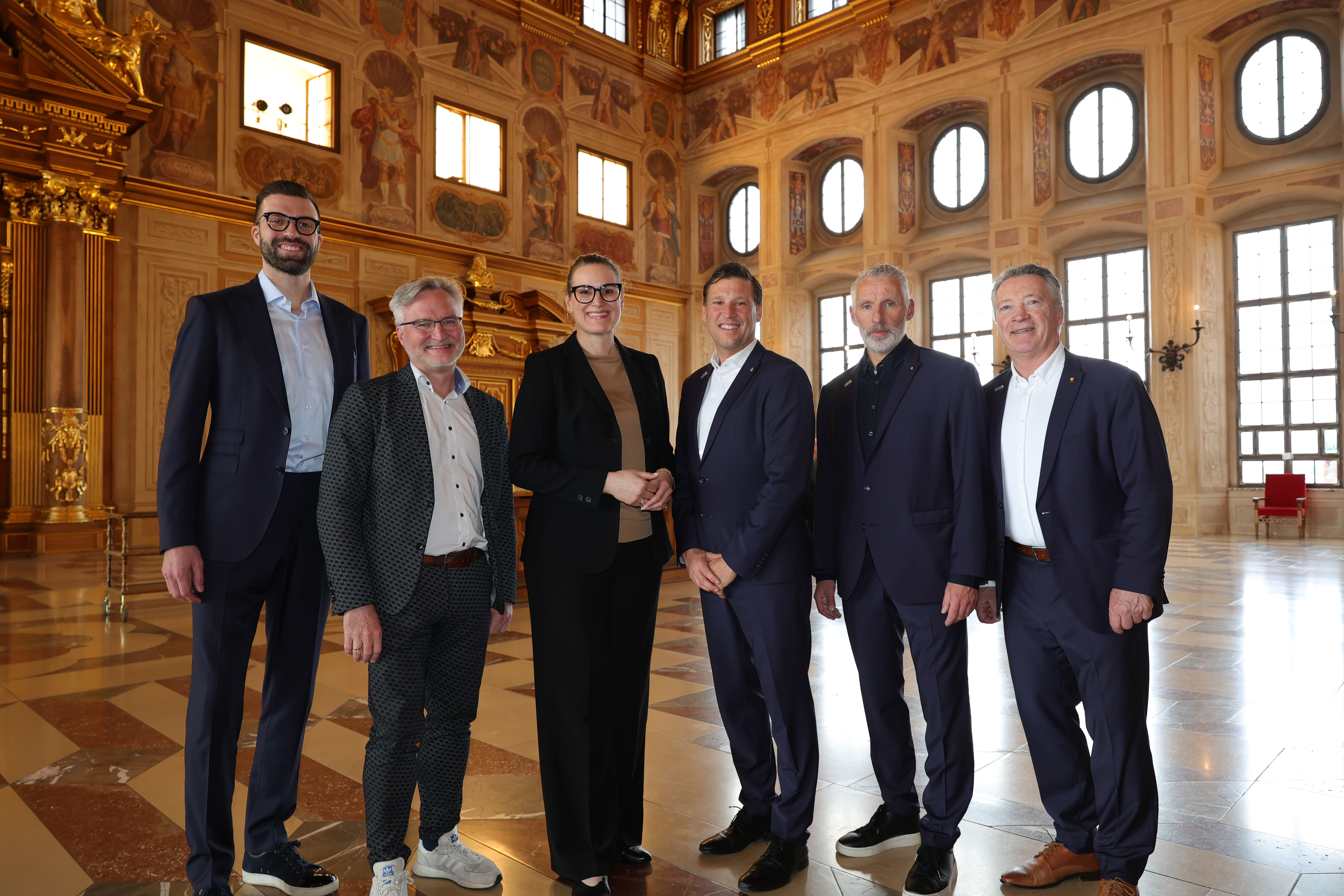 Ein Gruppenfoto von Maximilian Herber (Geschäftsführer der Augsburger Panther), Sportreferent Jürgen K. Enninger, Oberbürgermeisterin Eva Weber, Claus Gröbner (Generalsekretär des deutschen Eishockey-Bundes), Christian Künast (DEB-Sportdirektor) und Harold Klaus (Bundestrainer)