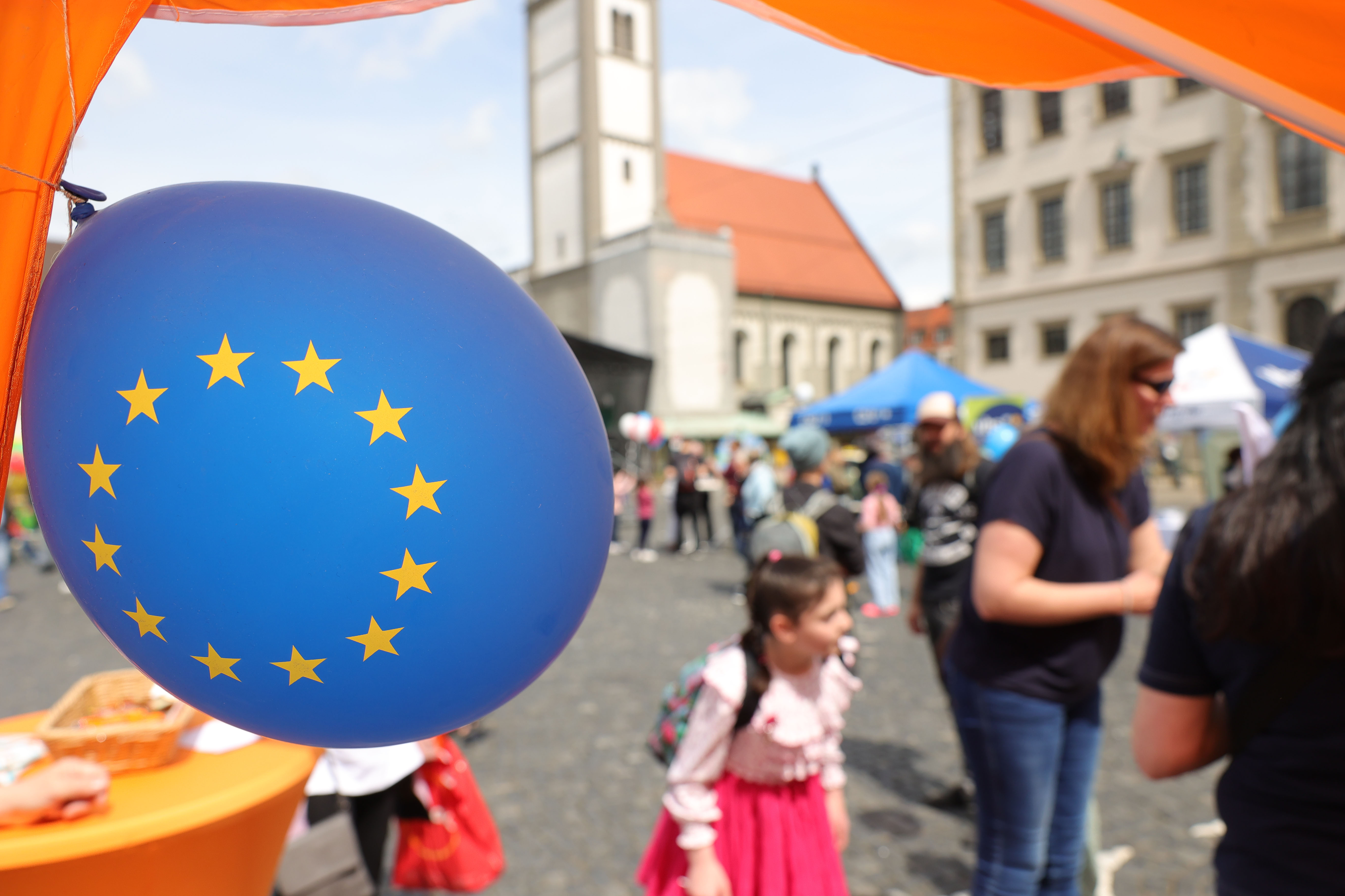 Im Vordergrund ein Luftballon mit der Europaflagge. Viele Menschen auf dem Rathausplatz