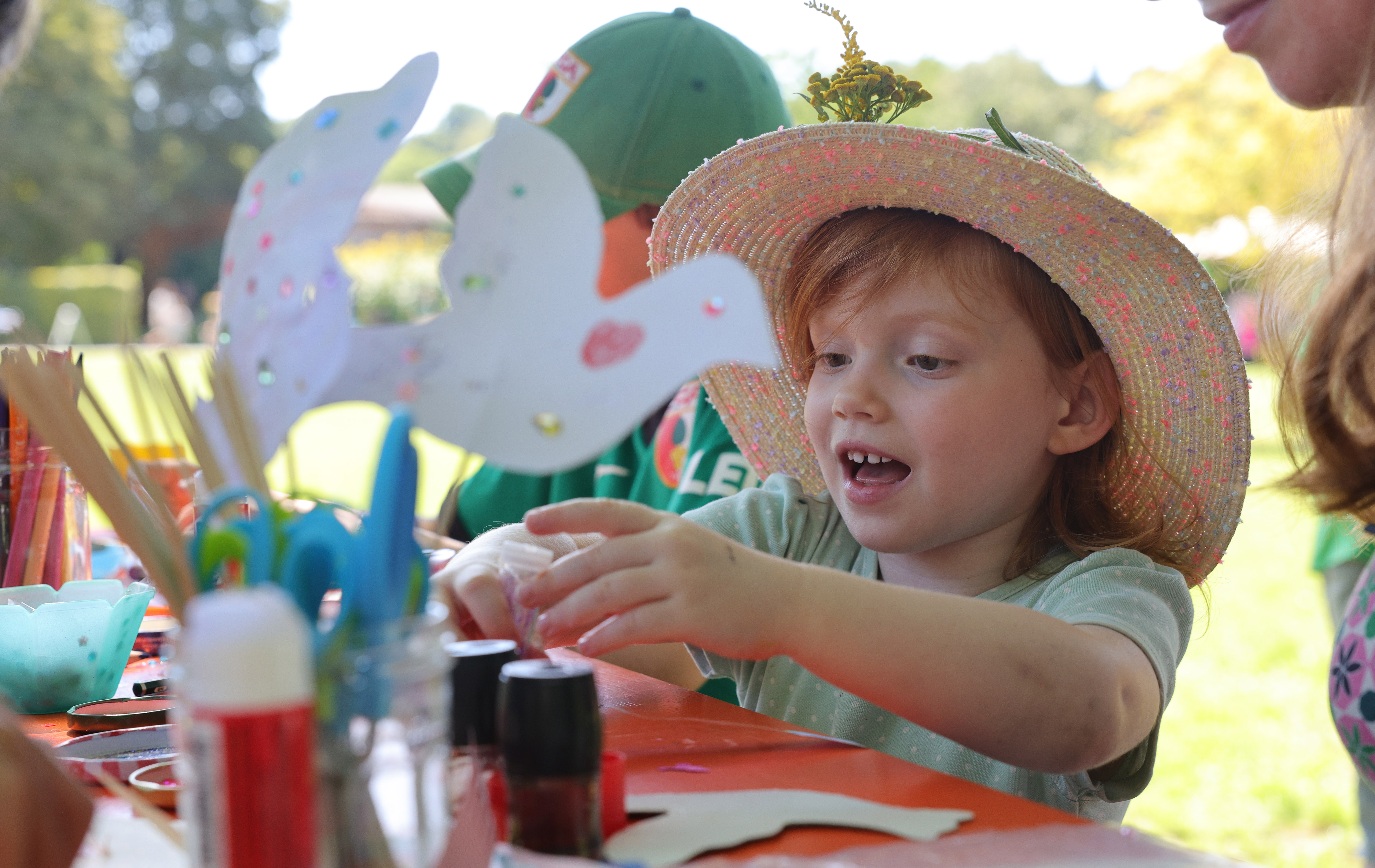 Ein Kind mit Hut malt beim Kinderfriedensfest mit 