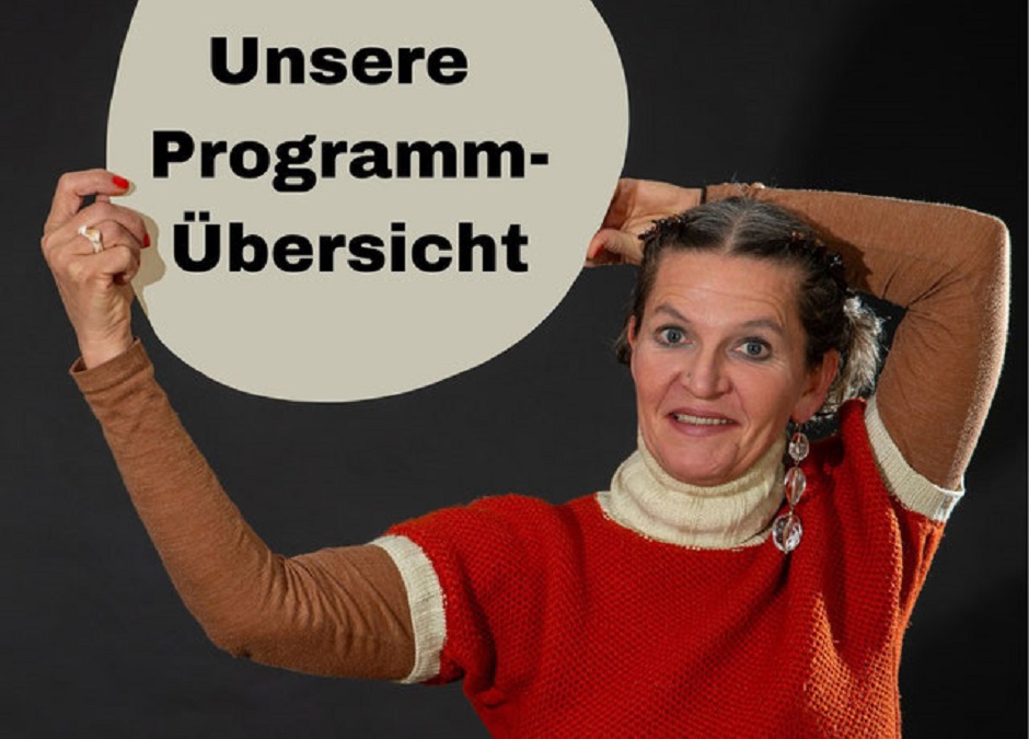 Eine Frau hält ein Schild hoch, auf dem Steht "Unsere Programm-Übersicht"