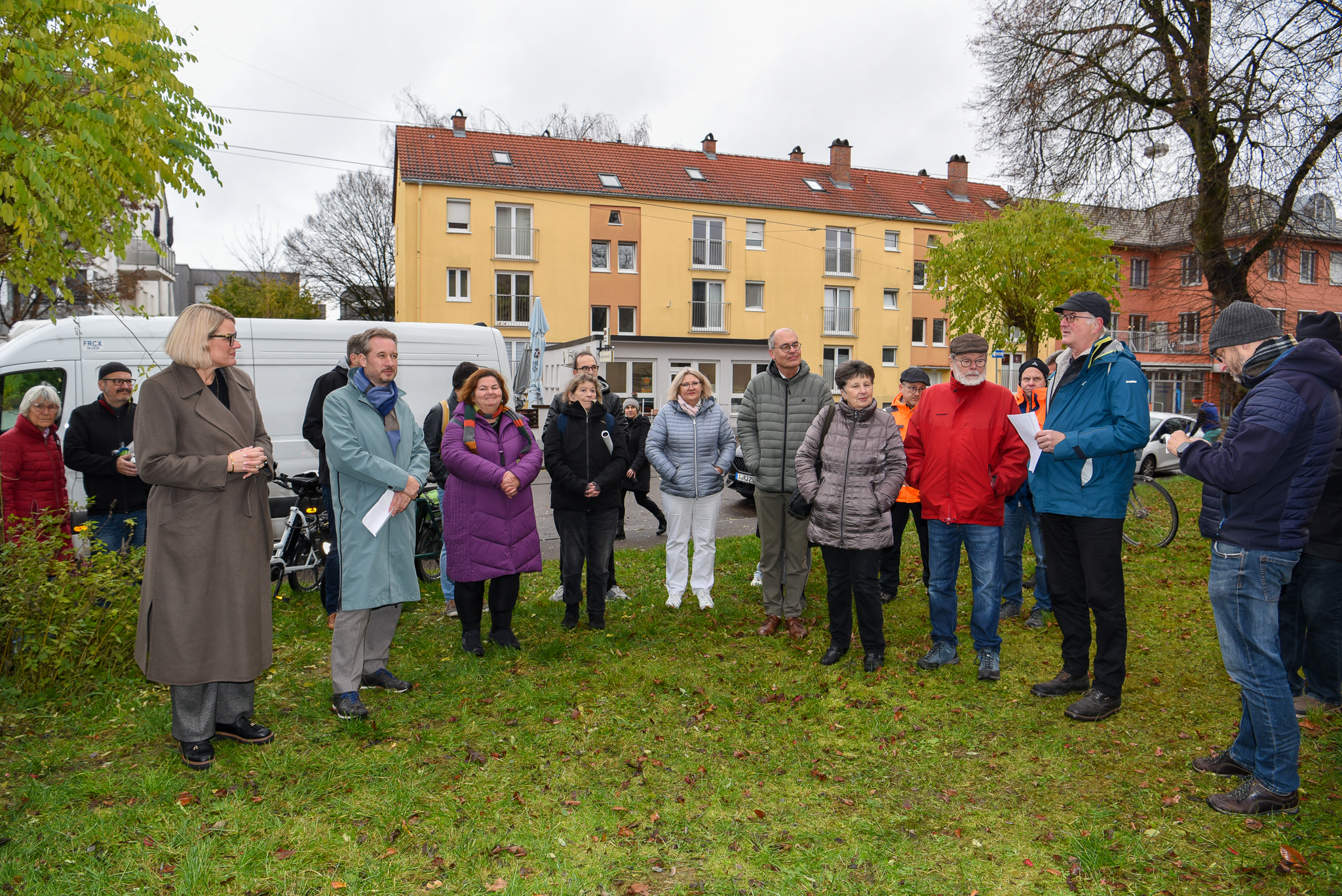 Viele Leute stehen auf einem Platz in einem Stadtteil