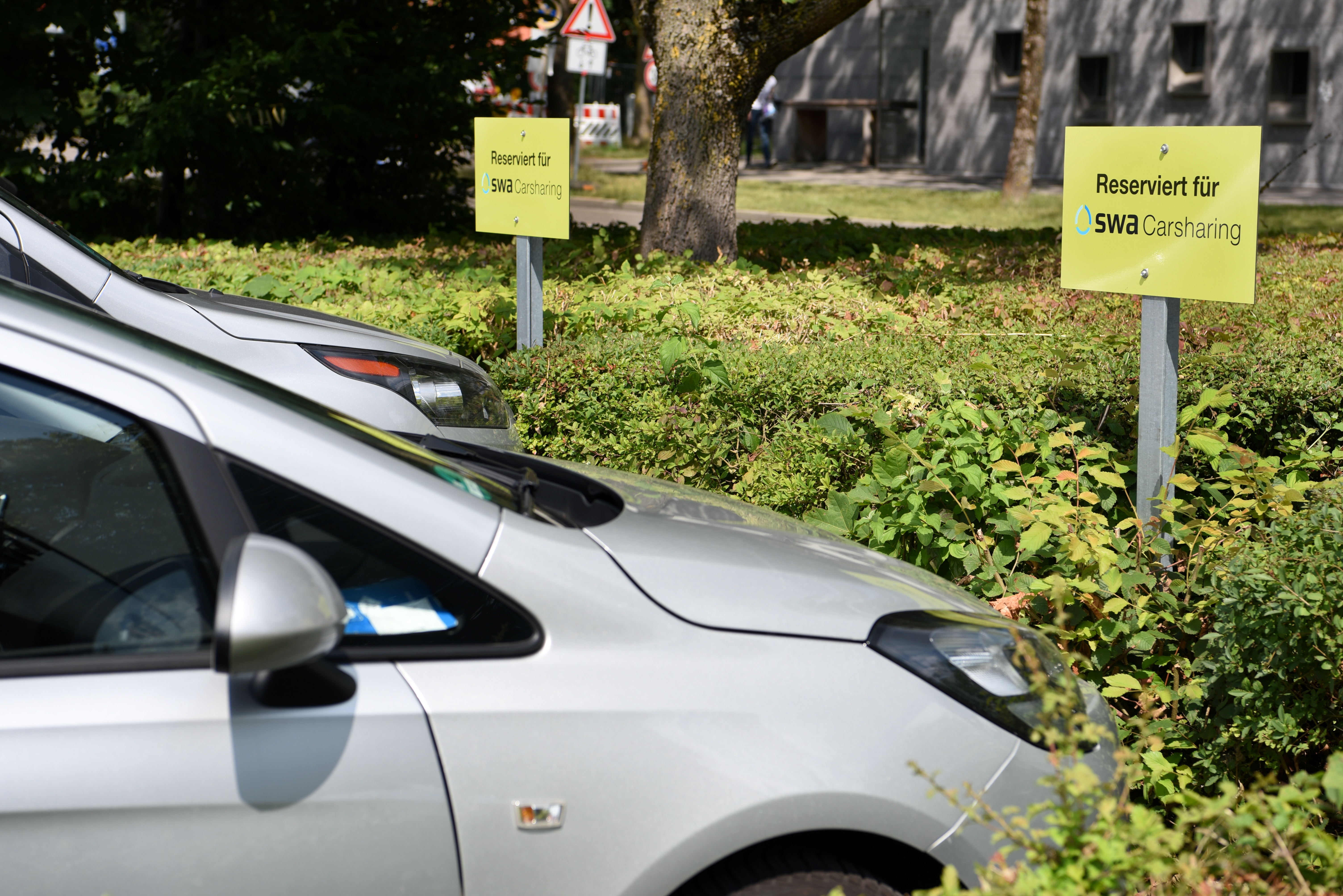 Auto parkt vor einem Schild mit der Aufschrift "Carsharing"