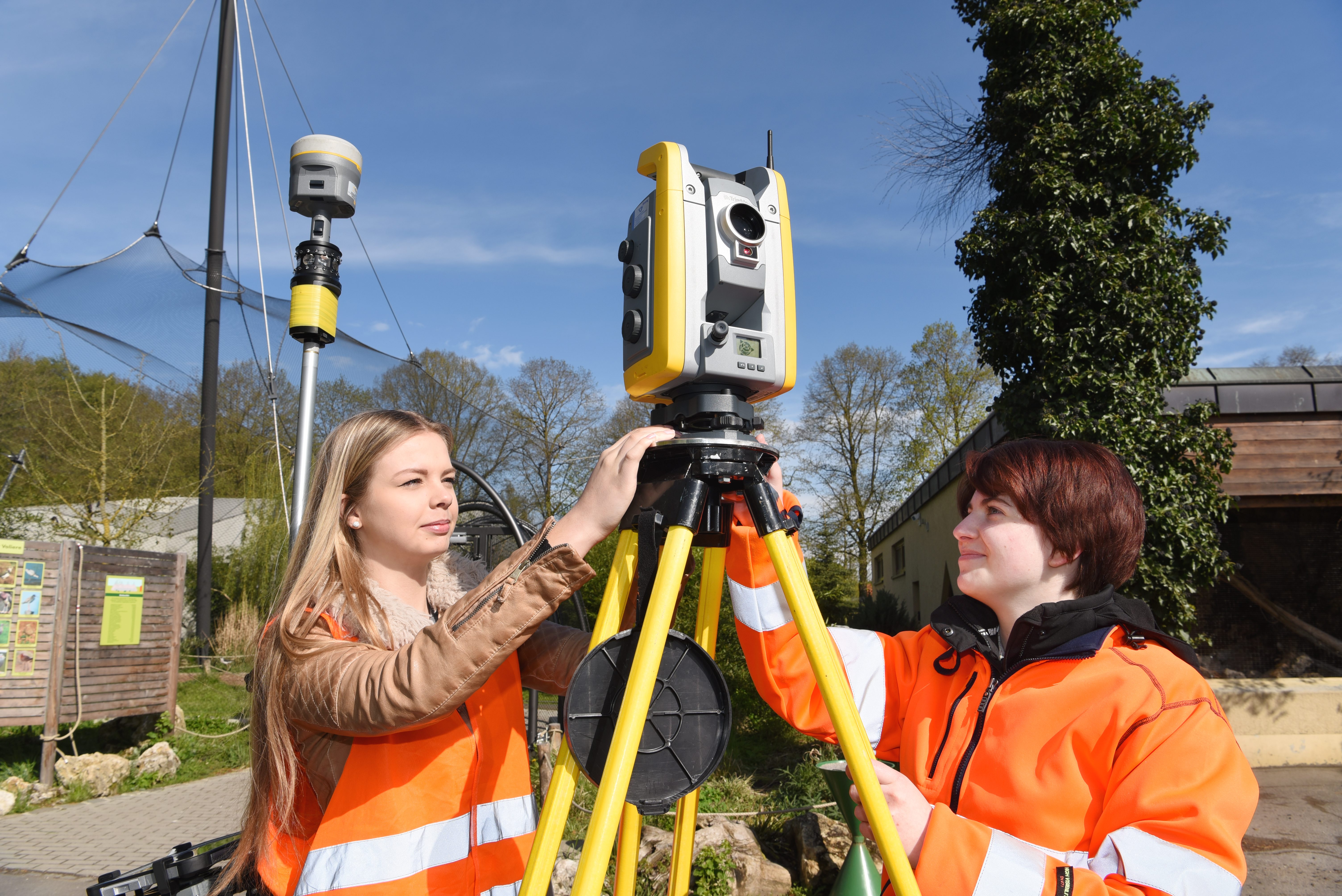 zwei Frauen in Schutzkleidung am Vermessungsinstrument