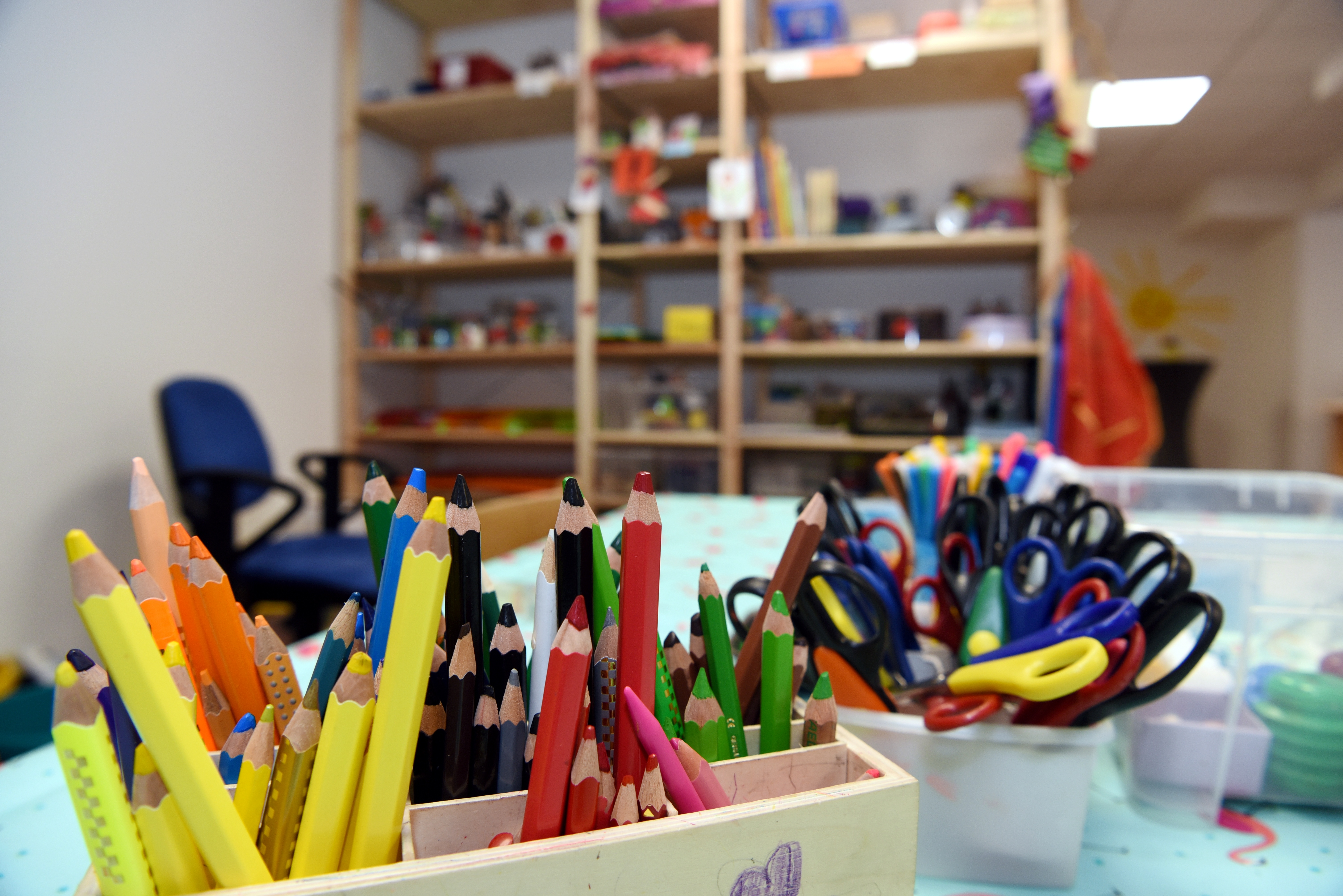 In einem Kindergarten stecken viele Stifte in einem Kasten auf einem Tisch