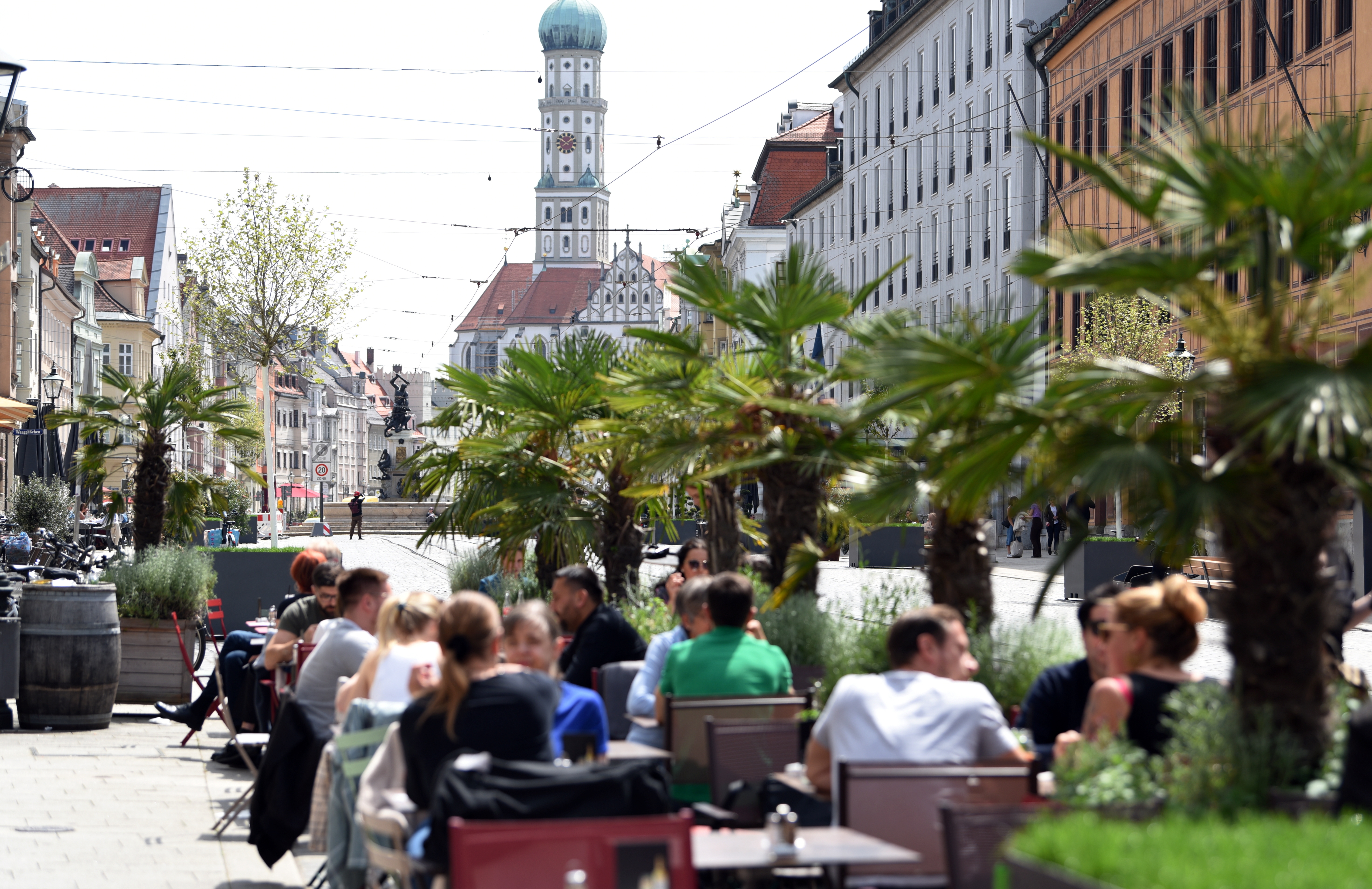 Viele Menschen sitzen am Moritzplatz an Tischen eines Straßencafes