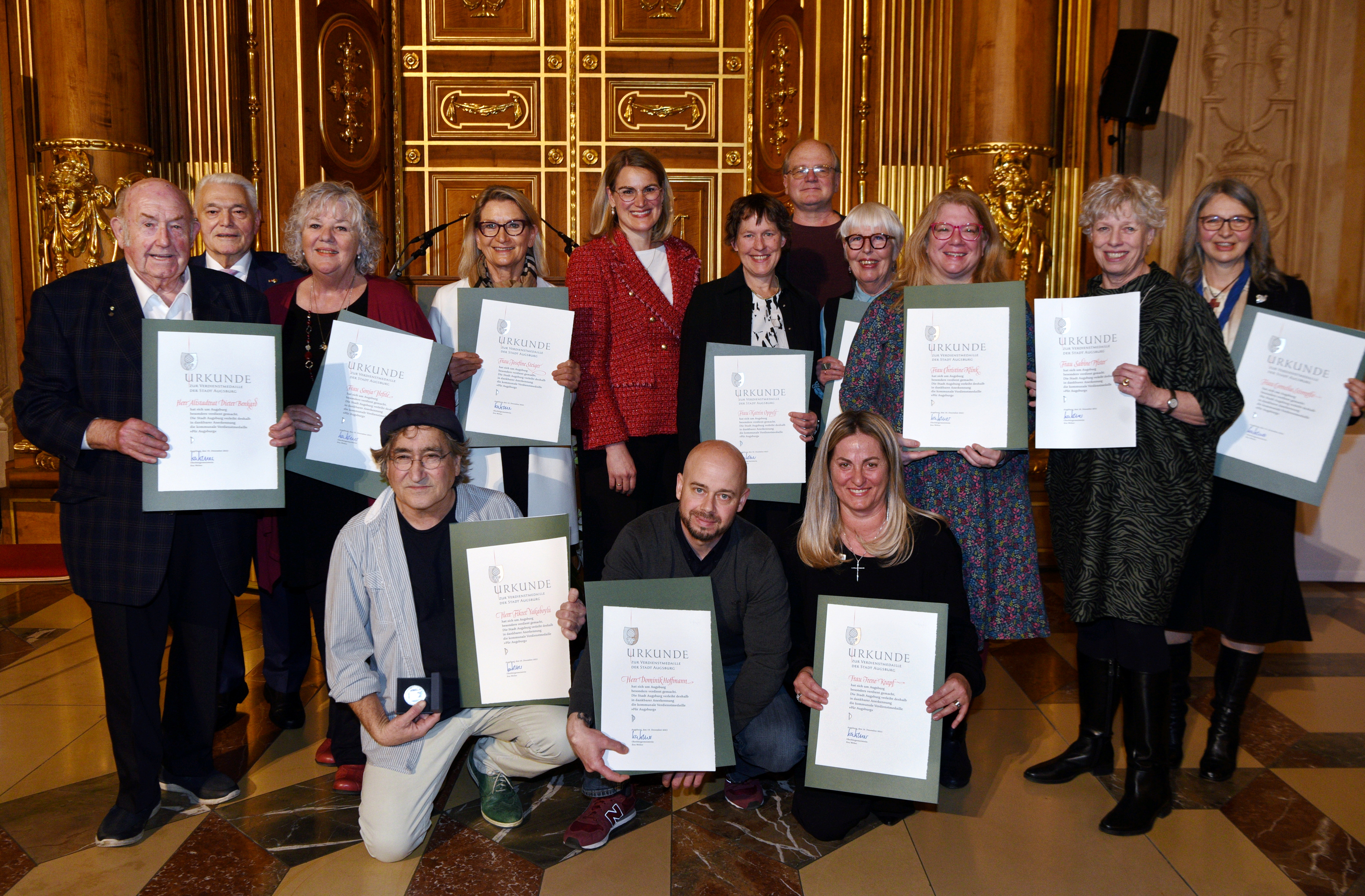 Gruppenbild von 14 Männern und Frauen, die jeweils eine Urkunde in der Hand halten