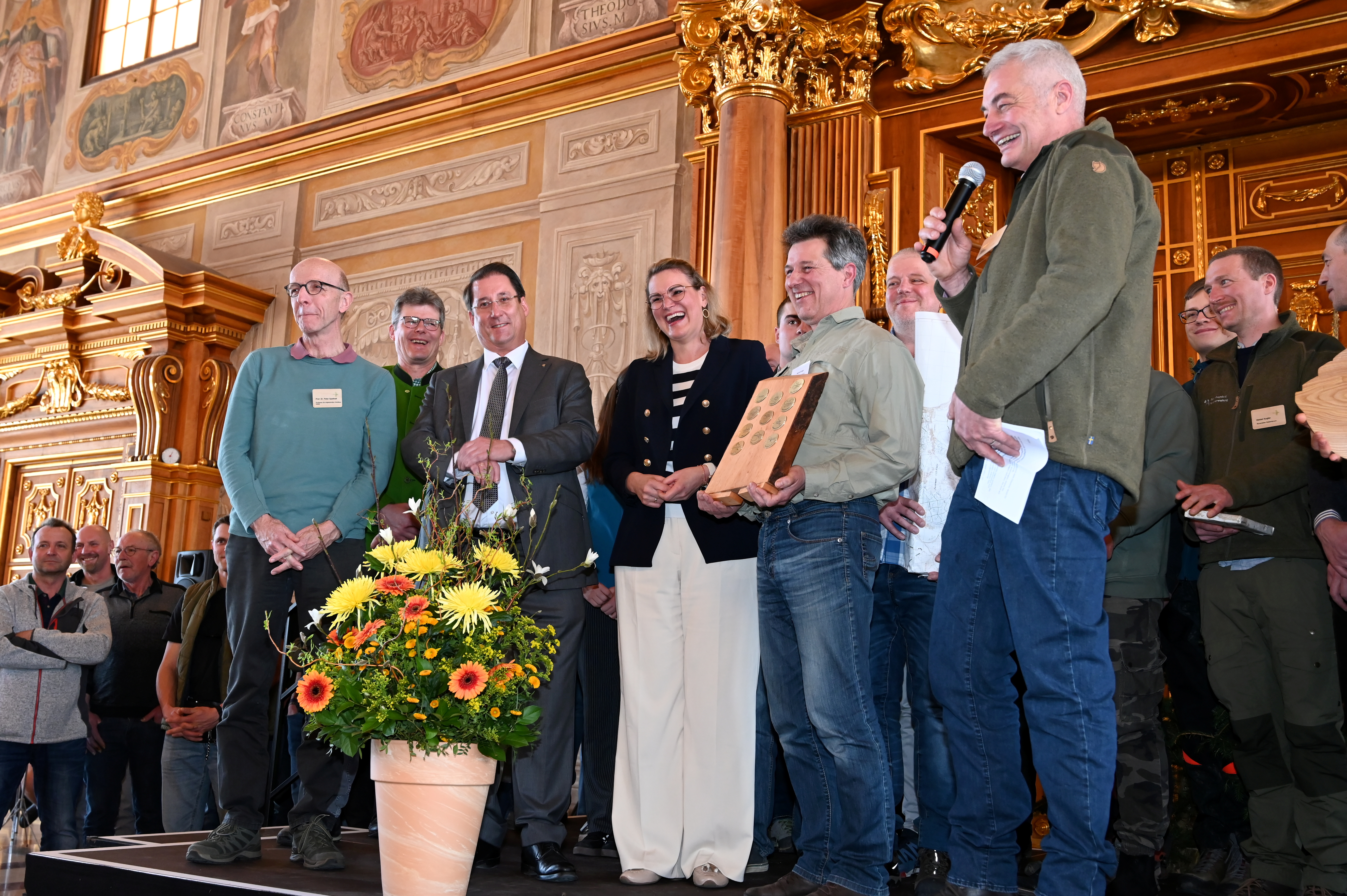 Eine Gruppe von Menschen auf einer Bühne im Goldenen Saal mit Oberbürgermeisterin Eva Weber. 