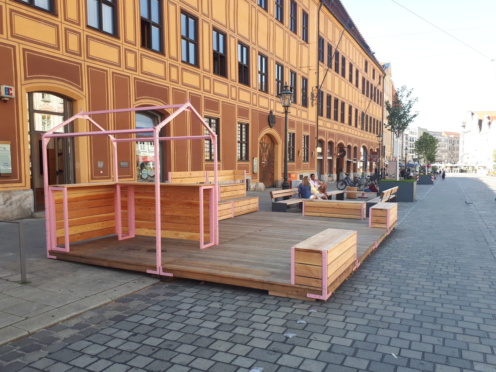 Vor einem Haus in der Maximilienastraße ist eine kleine Bühne aufgebaut