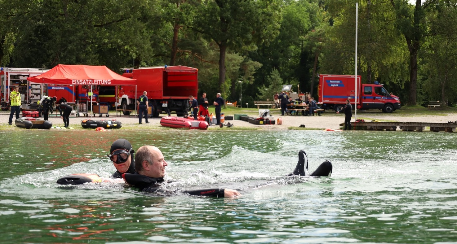 Ein Schwimmer zieht einen Mann aus dem Wasser